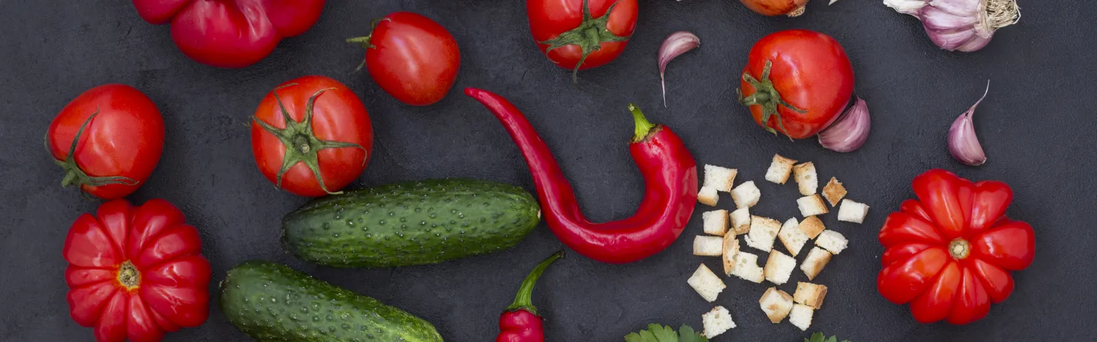 Ingredients for gazpacho sitting on top of a wooden table